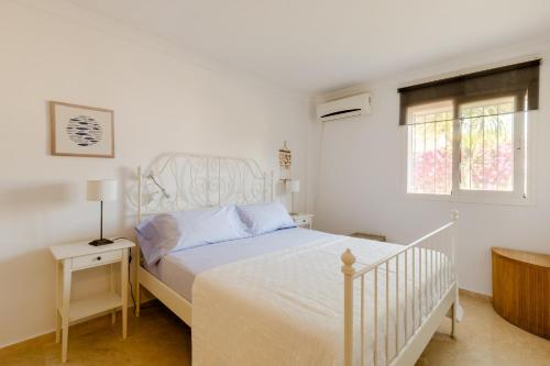 EsteponaApartamento Confortable Urbanización El Paraiso的白色的卧室设有白色的床和窗户。