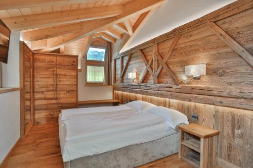 卡瓦莱塞Garni Maso San Michele的小木屋内的卧室,配有床和窗户
