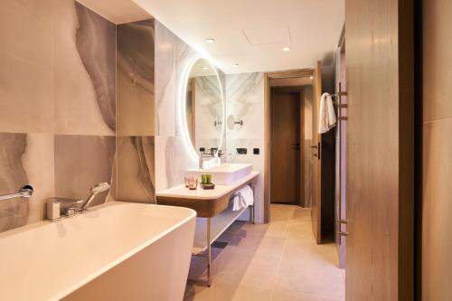 塔林弗热姆北欧酒店的带浴缸、水槽和镜子的浴室