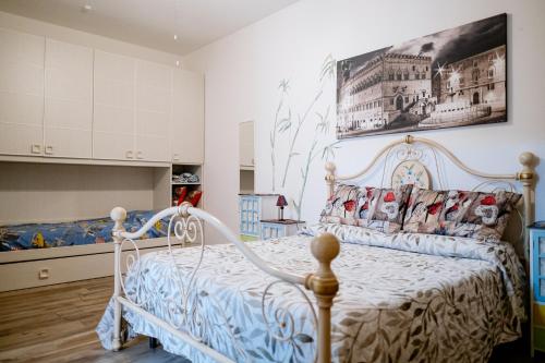 特拉西梅诺湖畔托罗La Poventa的卧室配有白色的床和墙上的绘画作品