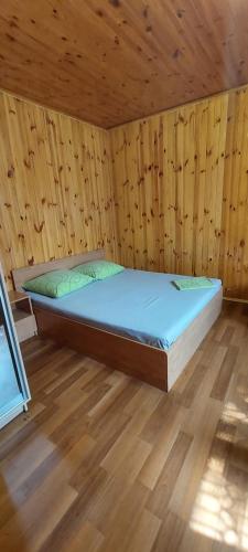 基辅Holiday Home at Fedkovycha St.的木质客房的一张床位,铺有木地板