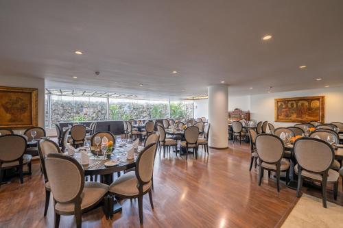 利马何塞安东尼奥行政酒店的用餐室配有桌椅