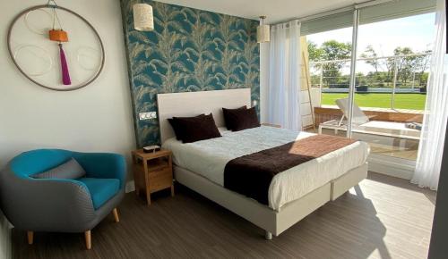阿格德角CAPAO Beach Hôtel的卧室配有床、椅子和窗户。