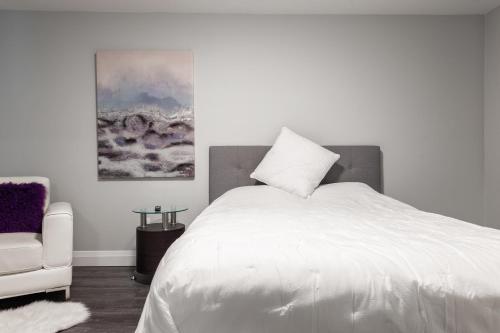 滑铁卢PRIVATE ROOM ENSUITE UPTOWN WATERLOO - e5的卧室配有白色的床和椅子