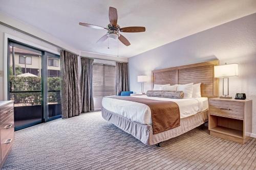 奥兰多Club Wyndham Orlando International的一间卧室配有一张大床和吊扇