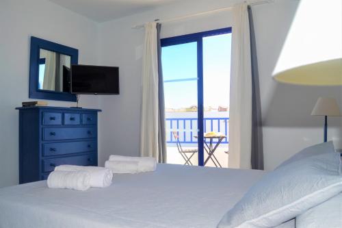 亚伊萨Casa Tacande的一间卧室设有一张带电视的床和一个阳台。
