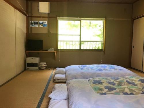 NosegawaMinshuku Kawarabi-so的一间卧室设有两张床和窗户。