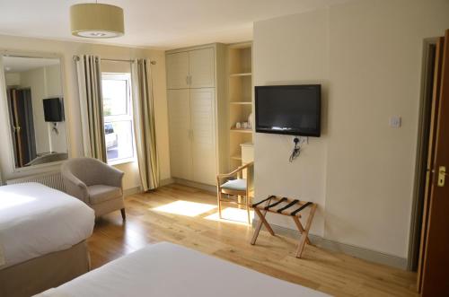 Allihies海景旅馆的酒店客房设有一张床和墙上的电视
