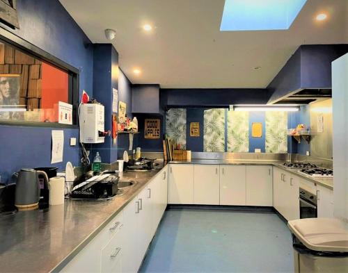 悉尼过境背包客经济汽车旅馆的一间拥有蓝色墙壁和白色橱柜的大厨房