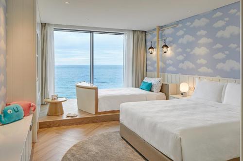 釜山Grand Josun Busan的一间带两张床的卧室,享有海景