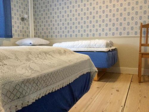EdsbynSTF Vandrarhem Edsbyn的卧室内的两张床,配有蓝色和白色的壁纸
