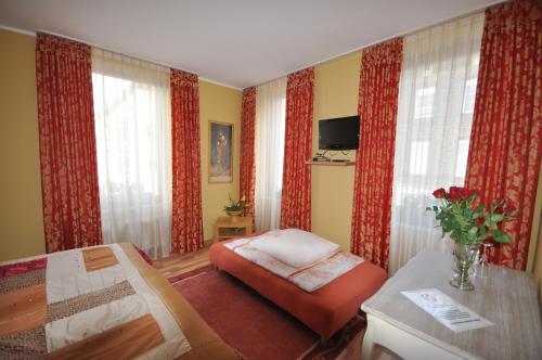 Münstermaifeld"雅典"餐厅酒店的一间卧室配有床、椅子和窗帘