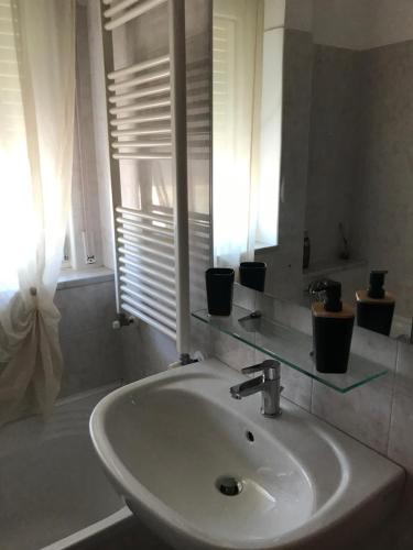 普蒂尼亚诺L'Alloggio Perfetto的带窗户的浴室内的白色水槽