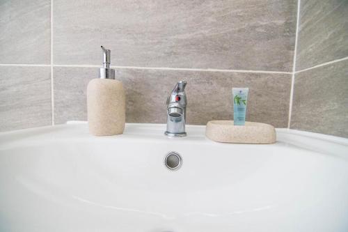 伊辛沃尔德住所@斋浦尔旅馆的浴室水槽,配有水龙头和2杯水