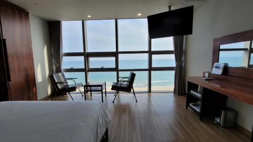 釜山海云台MS酒店的卧室配有一张床和一张桌子及椅子