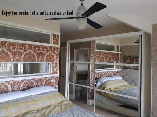 霍利韦尔The Mystical Orchard的一间卧室设有两张双层床和吊扇