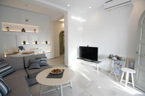 梅萨雷亚Santorini Garden Homes的带沙发和电视的客厅