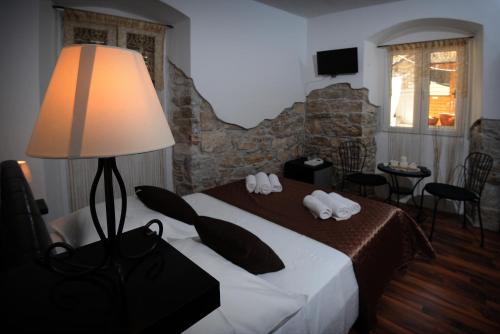 斯普利特拉斯塔客房公寓酒店的一间卧室配有一张带灯和椅子的床