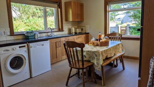 North TolstaRemuera, North Tolsta的厨房配有桌子和洗衣机。
