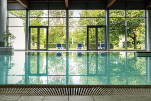巴特博尔希米纳瑞斯拜德巴洛酒店的大楼内带两把椅子的室内游泳池