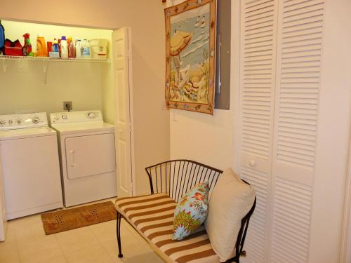 马可岛265 Villas at Waterside, Unit 201的厨房配有洗衣机和带枕头的椅子