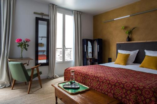 巴黎Hôtel La Nouvelle République & Hammam的酒店客房设有床、桌子和窗户。