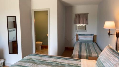 Jemseg杰姆塞格湖景汽车旅馆的一间卧室配有一张床,一个通往房间的门廊