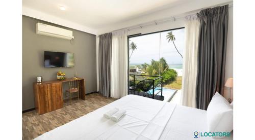 KalametiyaEndlessblue Resort Kalametiya的酒店客房设有一张床,享有海景。