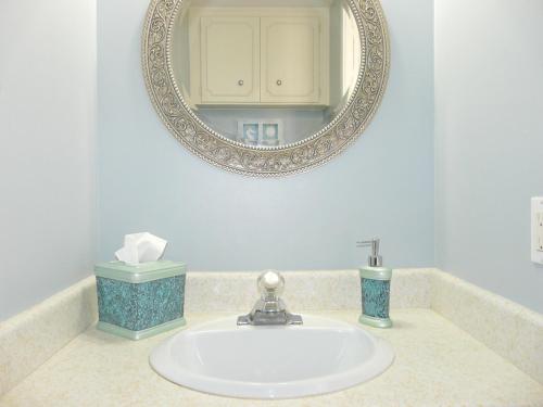 马可岛Tradewinds 1201的浴室设有盥洗盆、镜子和台面