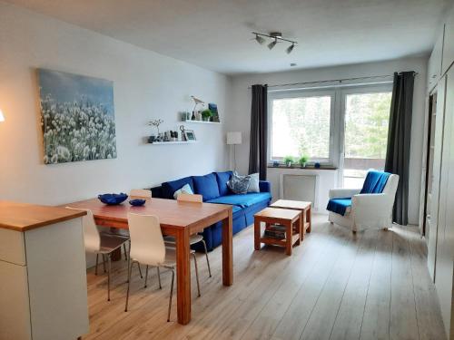 茵聂科里姆斯Kinder- und Familienhotel Nockalm的客厅配有蓝色的沙发和桌子