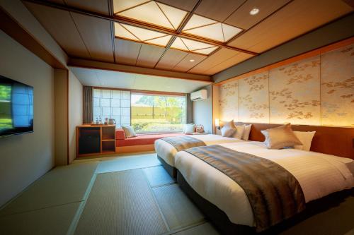 郡山荣乐馆日式旅馆的一间卧室设有一张大床和一个窗户。