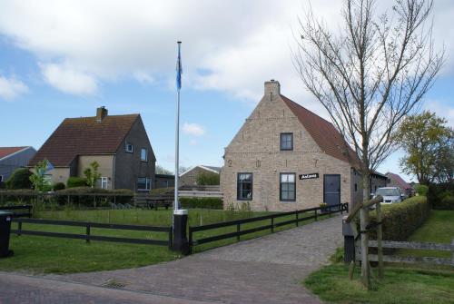 霍勒姆Antares-Ameland的一座古老的石头建筑,前面有栅栏