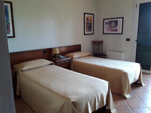 Azzano Decimo阿尔普提科酒店的酒店客房设有两张床和一张桌子。