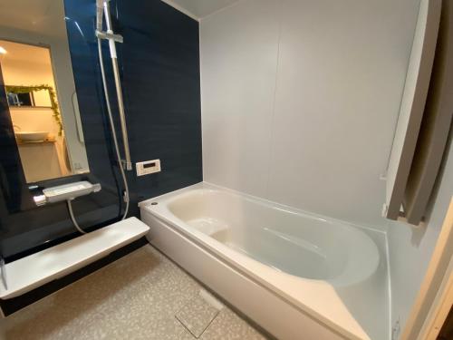 横滨雷屋旅馆的浴室设有白色浴缸及镜子