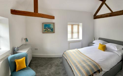 BredwardineThe Retreat的一间卧室配有一张床和一张蓝色椅子