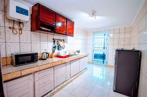 杜阿拉Stone House - Makepe, Douala的厨房配有白色橱柜和黑色冰箱。