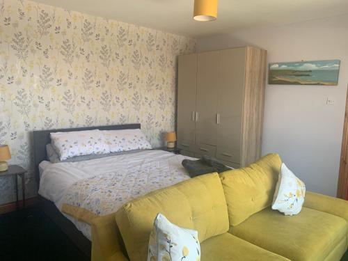 ArticlaveMussenden House的一间卧室配有一张床和一张黄色的沙发