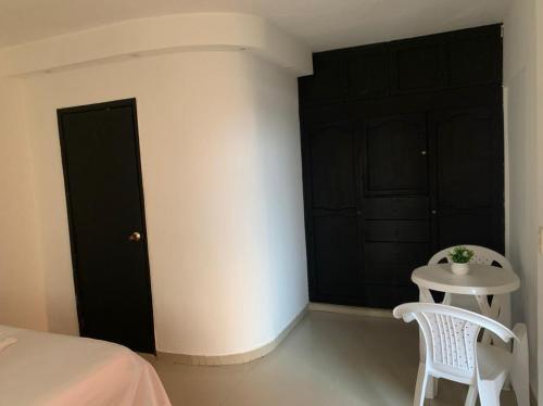 圣安德烈斯Zaida View的一间卧室配有一张床、一张桌子和黑色橱柜。
