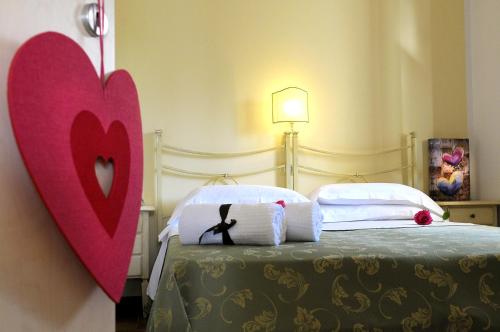 佩斯基奇Poggio di Luna Adults Only的卧室配有一张墙上红色心的床铺