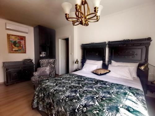 希贝尼克L&L Rooms Royal的一间卧室配有一张大床和一个吊灯。