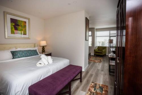 圣地亚哥One Bedroom Apartment with Luxurious Furnitures的卧室配有一张白色大床和紫色长凳