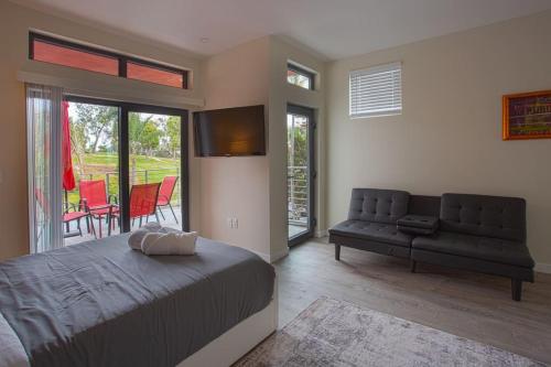 圣地亚哥Explore Balboa Park From Your Cozy Studio w Patio的一间卧室配有一张床和一张沙发,还设有一个庭院。