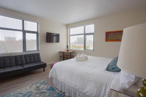 圣地亚哥Modern, Luxurious and Prime location All in One的一间卧室配有一张床、一张沙发和窗户。
