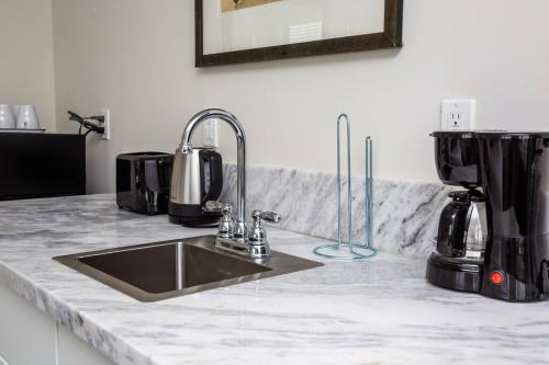 圣地亚哥Modern, Luxurious and Prime location All in One的厨房柜台配有水槽和咖啡壶
