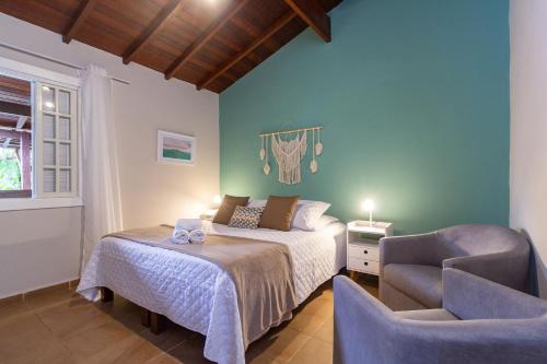 帕拉蒂Estrela do Mar Paraty的一间卧室配有一张床和一把椅子