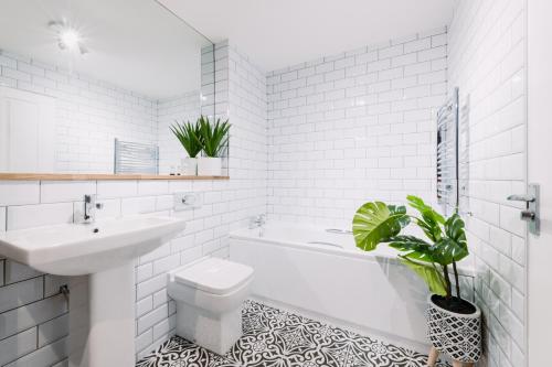 格拉斯哥SmartSleep Apartments的白色的浴室设有水槽、卫生间和浴缸。