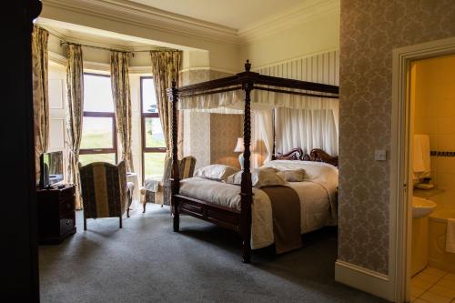 杜林巴里诺尔拉坎城堡田园酒店的一间卧室设有天蓬床和一间浴室。