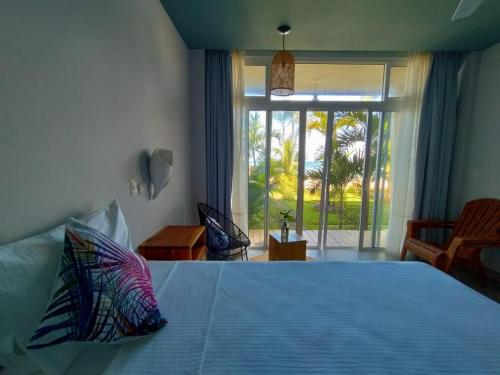 El TránsitoAlive Beach House的一间卧室设有一张大床和大窗户