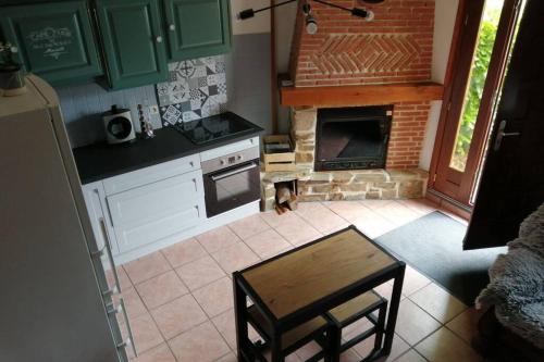 YervilleEscapade Normande的厨房配有绿色橱柜和砖炉