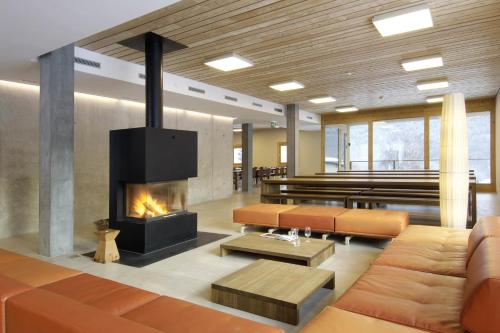 施库尔Scuol Youth Hostel的客厅设有壁炉和沙发。